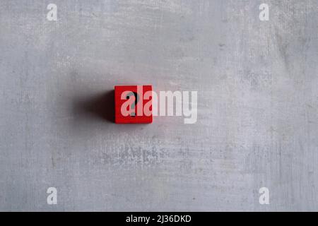 Red cubes with question mark on concrete background. Copy space for text. Ask, curious and doubt. Stock Photo