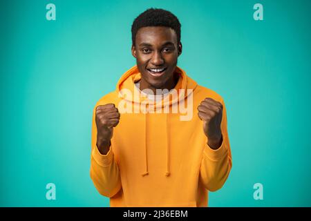 Portrait of overjoyed black man celebrating success in studio Stock Photo