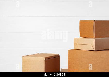 Group of cardboard boxes against white wooden wall Stock Photo