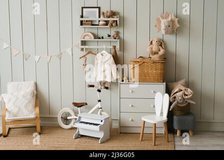 Scandinavian-style children's room: chest of drawers, bicycle, toys, piano toy Stock Photo