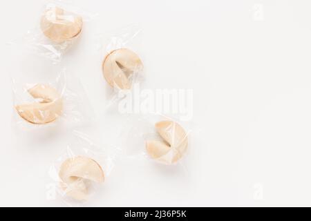 Fresh and tasty Chinese fortune cookies, individually wrapped in foil on white background. Top view, copy space Stock Photo