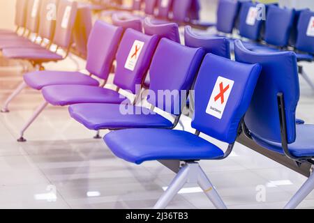 Bench chair in waiting area with keep distance space from seat social distancing. Stock Photo