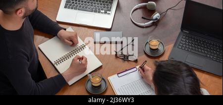 Business people sitting at the office desk using laptop, man and woman working together. Teamwork, modern creative office concept, above view, banner Stock Photo