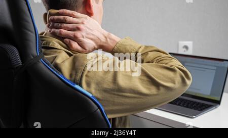 Man with bandage on neck works with document in laptop Stock Photo