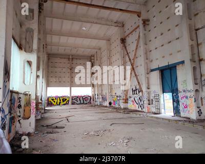03.29.2021 Warsaw, Poland. The inside of an abandoned rusty building. Graffiti on walls, glass on the floor. High quality photo Stock Photo