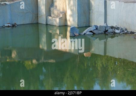 Granite quarry with large granite blocks Abandoned granite quarry with rain water. Granite mining in a quarry. Stock Photo