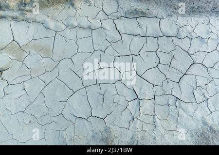 The soil cracked from drought, white clay with cracks. Texture and background for design Stock Photo