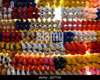 Amsterdam, Netherlands - March 12 2012: Rows of colorful clogs hanging to the ceiling in the store, lots of clogs pairs, wooden shoes, Dutch footwear Stock Photo