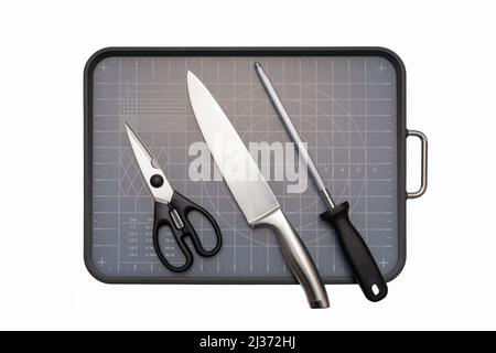 Various kitchen knives, scissors and cutting board Stock Photo