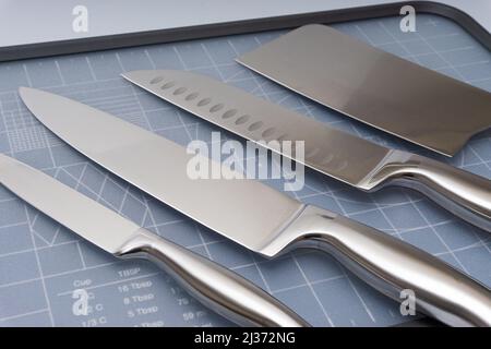Various kitchen knives, scissors and cutting board Stock Photo