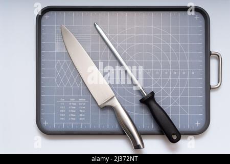 Various kitchen knives, scissors and cutting board Stock Photo