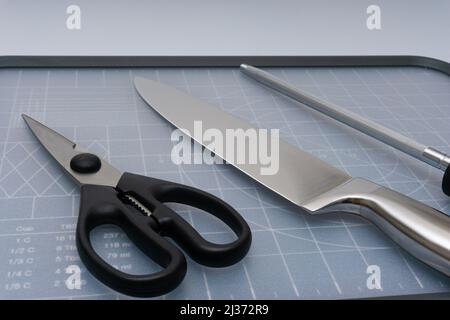 Various kitchen knives, scissors and cutting board Stock Photo