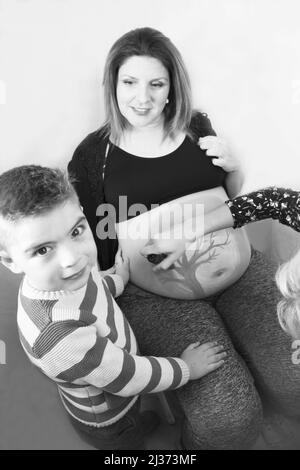 Eight month pregnant woman with three year old son. Body painting Stock Photo