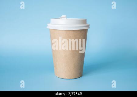 brown paper coffee mug on a blue background. Empty space for text and design on a cup of coffee. form for the name of the coffee or company or coffee Stock Photo