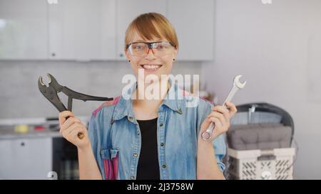 Happy smiling red-haired caucasian woman with tools looking at camera. High quality photo Stock Photo