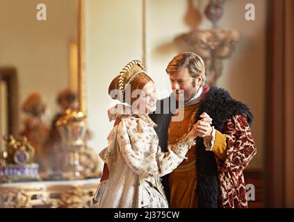 Sharing a timeless love. A king and queen dancing together in their palace. Stock Photo