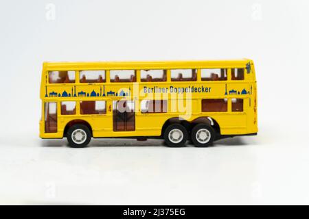 Miniature yellow tporist big bus isolated on white background, double decker metal bus mini toy front view, slanted angle object Stock Photo