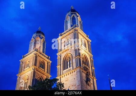 The cityscape of Zurich at night with the river Limmat and the Grossmuenster cathedral, Zurich Switzerland, Europe. Stock Photo