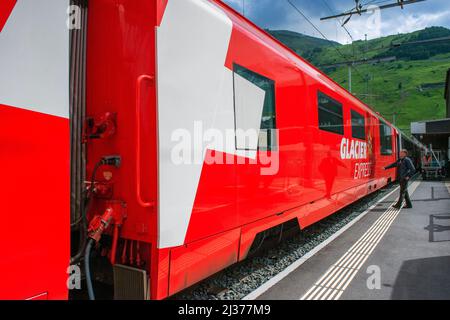 The glacier express train stoped in Andermatt station. This train goes from Zermatt to St.Moritz, panoramic train that crosses Alps through the Unesco Stock Photo