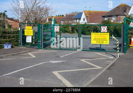 Closed and locked school gates with authorised vehicles only and 5mph speed limit signs at a primary school in England, UK. Stock Photo
