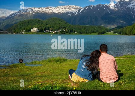Romantic couple and the mountain lake of St. Moritz in the summer time, Sankt Moritz, Engadin, Grisons, Switzerland.