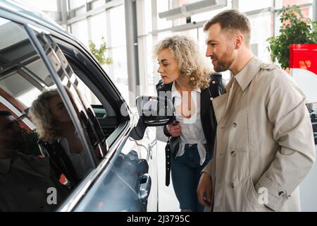 Young couple choosing their new car in a car dealership Stock Photo