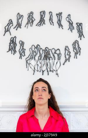 London, UK.  6 April 2022. A staff member poses with 'FITTING IN', 1973/2006, by Rosemarie Castoro. Preview of ‘Working Out’, artist Rosemarie Castoro’s first solo UK exhibition.  Four decades of her minimal and post-minimal work from the New York art scene are displayed at Thaddaeus Ropac’s gallery in Mayfair 6 April to 21 May 2022.  Credit: Stephen Chung / Alamy Live News Stock Photo