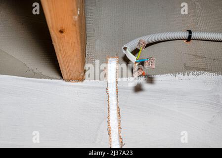 A furrow cut out in the facade of the house from polystyrene for an electric cable for connecting the led lamp. Stock Photo