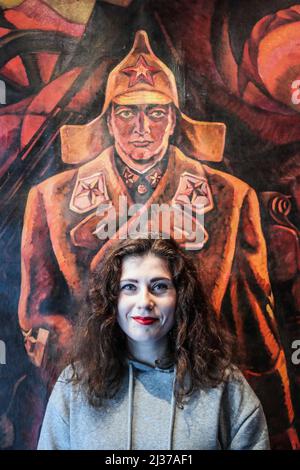 London UK 06.April 2022 the Curator with "Red Soldier" by Nekliuyenko, Nikolai Pavlovich – Ukrainian artist Hartmond is a British Ukrainian writer, curator, and creative consultant. Having graduated from the University of Oxford in 2014, she ran the Triptych gallery in Kyiv for 6 years. After 2 years in lockdown, 10 days of war, and 5 days on the road, she returned to Oxford again. Myroslava curates exhibitions on topics as diverse as Lenin’s cult of personality, Norwegian black metal, and traces of Ukraine’s Jewish heritage, and brought the first HR Giger retrospective to Ukraine in 2019. She Stock Photo