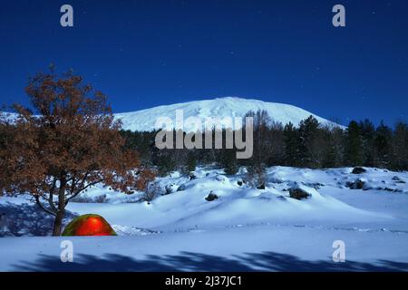 lighting tent and winter landscape of Etna Park under the moonlight, Sicily Stock Photo