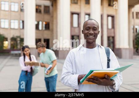 Loans for education concept. Portrait of african american male student posing near university building Stock Photo