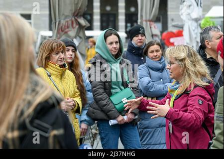 06 April 2022, Saxony-Anhalt, Halle (Saale): Guest guide Beate Krauße (r) leads refugees from Ukraine through the city. In addition to relevant points such as the city administration building, shopping opportunities, gastronomic and museum facilities and selected tourist points in the inner and old town areas are presented. Photo: Heiko Rebsch/dpa Stock Photo