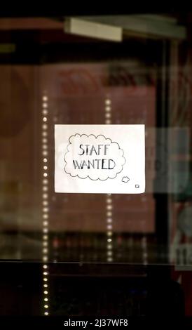 Handwritten sign in the window of a business advertising for staff. No people. Stock Photo