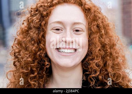 Happy redhead girl smiling on camera outdoor - Focus on ginger woman face Stock Photo