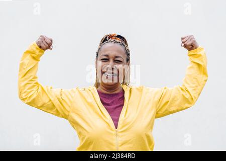 Senior African woman doing exercise workout routine outdoor - Focus on face Stock Photo