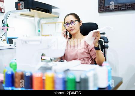 Embroidery, handicrafts, hobbies, SME business, family business, Portrait of Asian female designers are doing by designing patterns using automatic Stock Photo