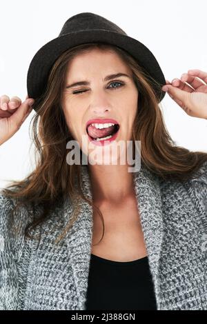 This fashionista knows whats in. Studio shot of a stylishly dressed young woman posing against a coloured background. Stock Photo