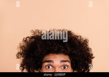 Cropped view portrait of attractive funky amazed stunned guy with chevelure staring isolated over beige pastel color background Stock Photo