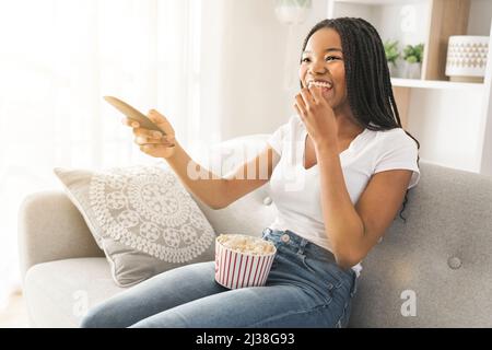 Portrait of teenager watching tv with pop corn on hand Stock Photo