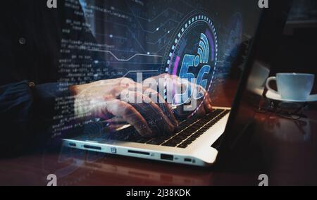 5G high-speed mobile phone communication and iot network symbol and man typing computer keyboard. Hands on laptop. Network, cyber technology and backg Stock Photo