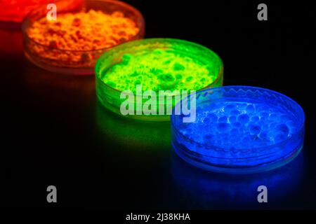 Fluorescent organic materials powder of red, yellow, green color for production OLED displays in UV light.Closeup. Stock Photo