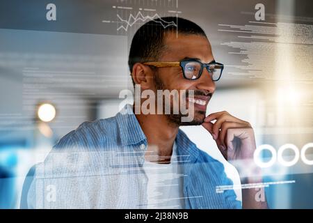 Binary is his second language. Shot of a happy computer programmer working on new software at his computer. Stock Photo