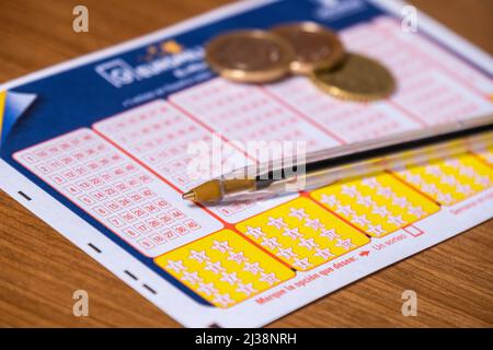 Valencia, Spain; 5th April 2022: Detail of an unfilled Euromillions ticket, a pen and some coins. Stock Photo