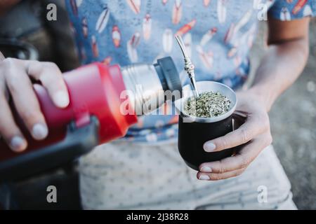 close up of a young latin man drinking mate in a natural space, at afternoon. Latin beverage. Stock Photo