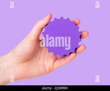 Settings concept. Woman hand holding gear on purple background. Applications technical parameters. High quality photo Stock Photo