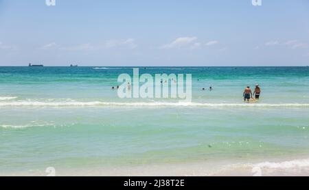 MIAMI BEACH, FLORIDA - JULY 27, 2010: Tourists sunbath, swim and play on South Beach in Miami Beach, Florida, USA. Stock Photo