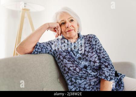 portrait of elderly woman sit on the sofa at home Stock Photo