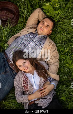 happy stylish couple lying in green grass Stock Photo
