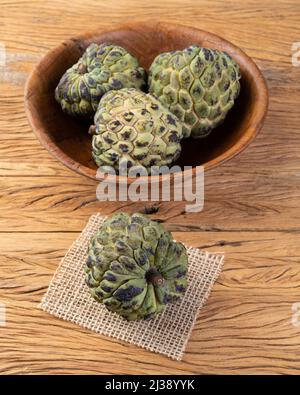 Sugar apples or custard apples in a bowl over wooden table. Stock Photo
