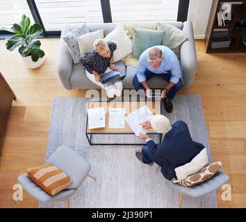 Hes got all the data you need. Aerial shot of a group of businesspeople going through paperwork. Stock Photo
